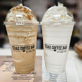Two 24 oz plastic cups with black "Texas Coffee Bar" print, milk coffee shake and vanilla milkshake with whip, dome lids and black straws, on menu