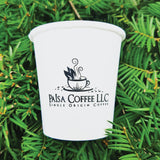 Custom printed 4 oz paper cup with "Paisa Coffee LLC" text and cup image, laying on green pine needles