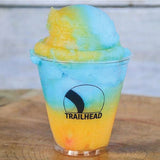 5 oz. custom printed plastic cup with logo and blue and yellow slushy on wooden table.