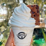 9 oz plastic cup with Pinto’s Farm logo, filled with soft serve ice cream and cookie chunk, in park setting