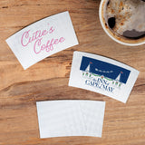 Three White Coffee Sleeve of varying logos beside a cup of coffee, on a wooden table
