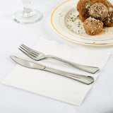 Blank 3-PLY White Lunch Napkin with a fork and knife resting on top, next to a plate of meatballs, on a white cloth table
